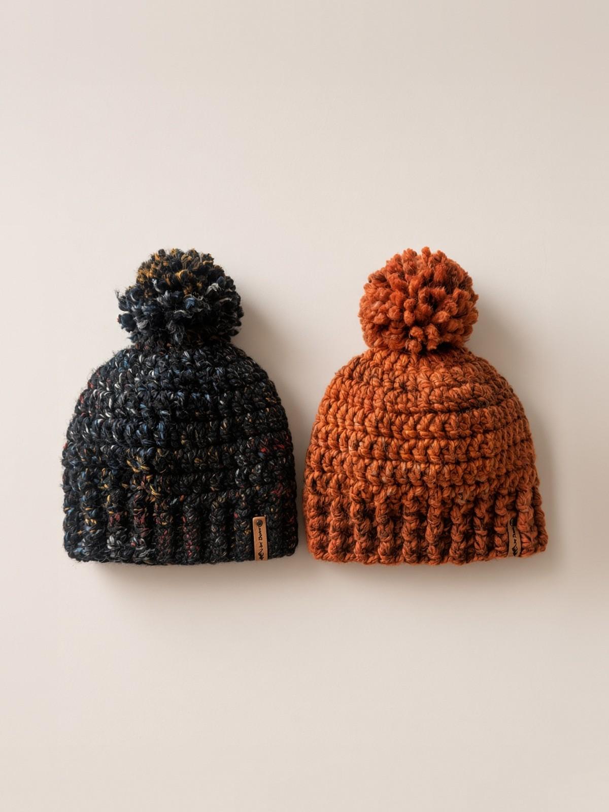 Two handmade pom-pom beanies in rust and speckled charcoal yarn